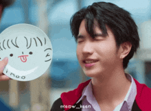a man holding a plate with a face drawn on it