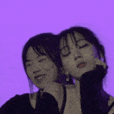 two young women are standing next to each other with their eyes closed and smiling .