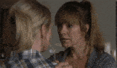 two women are kissing each other in front of a tv screen that says itv