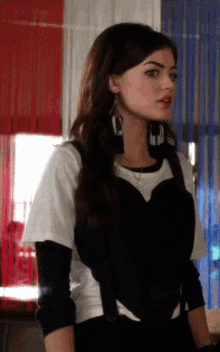 a woman wearing a white shirt and black top with a heart shaped top