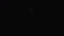 a man in a mask is flying through the air in the dark .