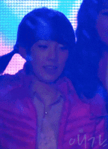a woman in a red jacket holds a microphone in front of a blue background