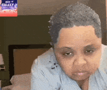 a woman is making a funny face while sitting on a bed in a room .
