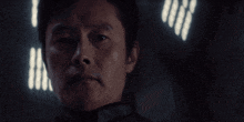 a blurred image of a person in a dark room with a light shining through the bars
