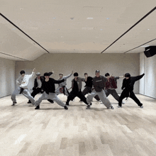 a group of young men are dancing in a large room and one of them is wearing a sweatshirt that says ' supreme '