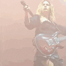 a woman is playing a guitar on a stage .