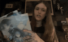 a woman is holding a piece of paper with a picture on it
