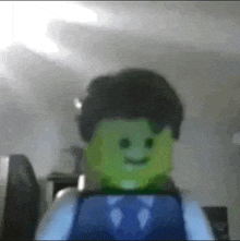 a lego man in a suit and tie is smiling in a blurry photo .