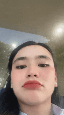 a close up of a woman 's face with her eyes closed and red lips