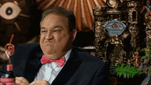 a man in a suit and bow tie is making a face
