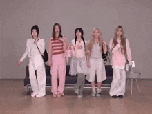 a group of girls are standing in front of a couch