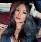 a woman is sitting in a car with her hand on her head