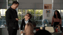 a group of people in a classroom with a sign on the wall that says back when you open a book