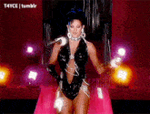 a woman in a black bodysuit is standing in front of a microphone on a stage with tumblr written on the bottom right