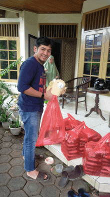 a man holding a stuffed animal wearing a shirt that says di on it