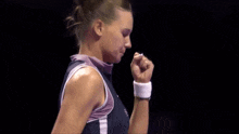 a woman with her fist in the air wearing a wristband that says nike