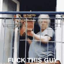an elderly woman holding a potted plant on a balcony with the words fuck this guy written below her