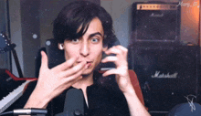 a young man with a marshall amplifier in the background