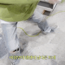 a person wearing a green jacket and checkered shoes