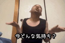 a man in a black tank top is making a funny face in front of a sign that says ' ? '