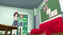 two girls standing in front of a red couch in a room