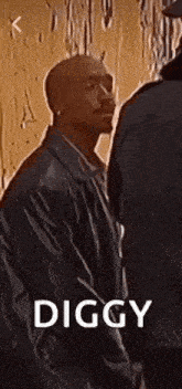 a man in a leather jacket is standing next to another man and talking to him .