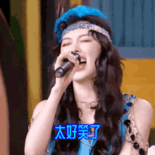 a woman singing into a microphone with chinese writing on the bottom right