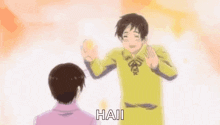 a man in a yellow shirt is standing next to another man in a pink shirt and making a funny face .