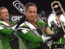 a man playing a trombone in a band with a yamaha logo in the background