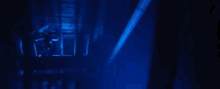 a woman is standing in a dark room with blue lights behind her .