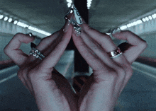 a close up of a person 's hands with rings on