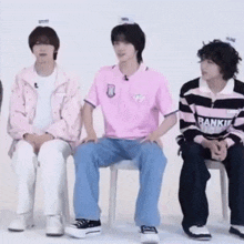 a group of young men are sitting in chairs .