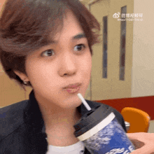 a person drinking through a straw from a cup that says ' nexttide ' on it