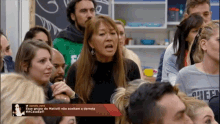 a group of people are gathered in a room with a sign that says cheer on it