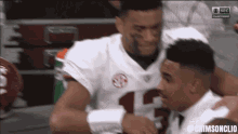 two football players hugging each other with sec championship written on the bottom