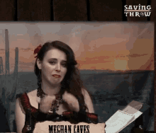 a woman is sitting in front of a sign that says meghan cates