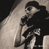 a man wearing a los angeles shirt is talking on his cell phone