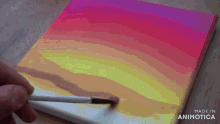 a person is painting a rainbow on a canvas that is made in animatica