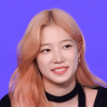 a close up of a woman with pink hair wearing a choker and smiling .
