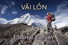 a man with a backpack is standing on top of a mountain .