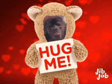 a teddy bear with a picture of a man on it holding a sign that says hug me