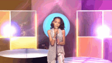 a girl singing into a microphone in front of a purple circle