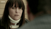 a woman wearing a neck brace talks to a man on bbc television