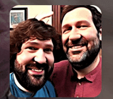 two bearded men are posing for a picture and smiling