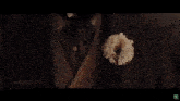 a close up of a flower on a wooden table in the dark .