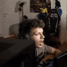 a man wearing headphones is sitting in front of a computer monitor in a room .