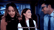 a man and two women are standing next to each other .