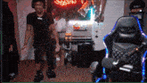 a man wearing headphones stands in front of a microphone in a room with a neon sign that says crew