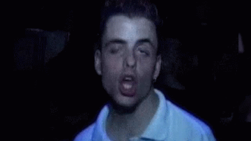 a man is making a funny face with his eyes closed and his mouth open .