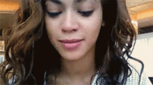 a close up of a woman 's face with curly hair .